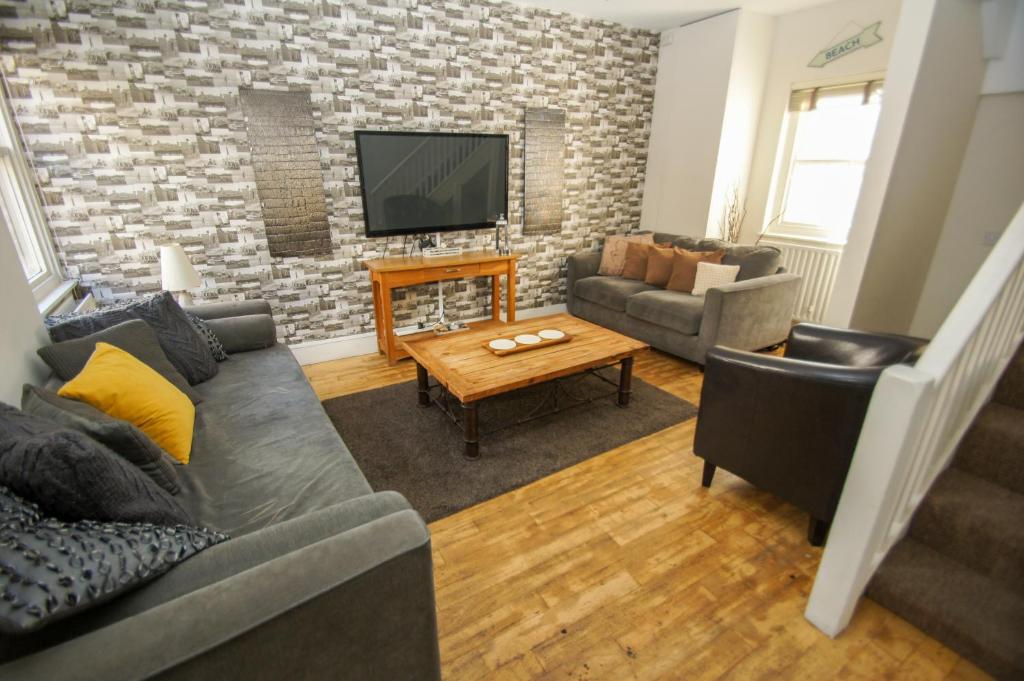 uma sala de estar com um sofá e uma televisão em Wentworth House - by Brighton Holiday Lets em Brighton & Hove