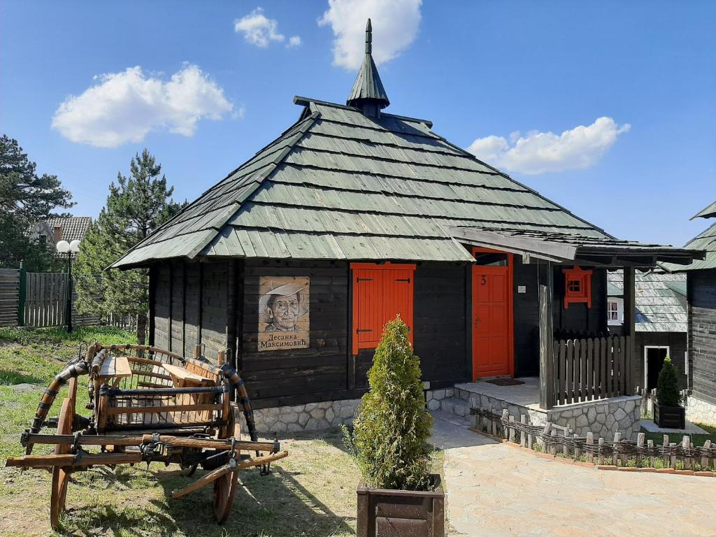a small black and red building with a church at El Paso City, Zlatibor - Wooden Cottages Unique, Treehouse, Wild West Rooms, accommodation 1-6 people in Zlatibor