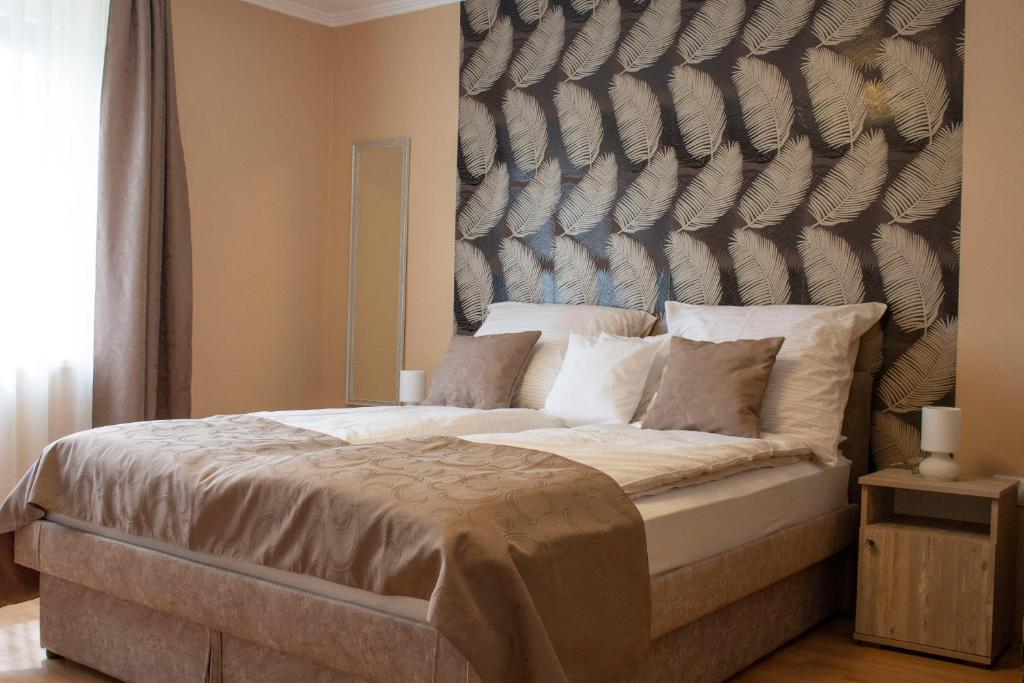 1 dormitorio con 1 cama grande y cabecero grande en Ilona Apartman, en Gyula