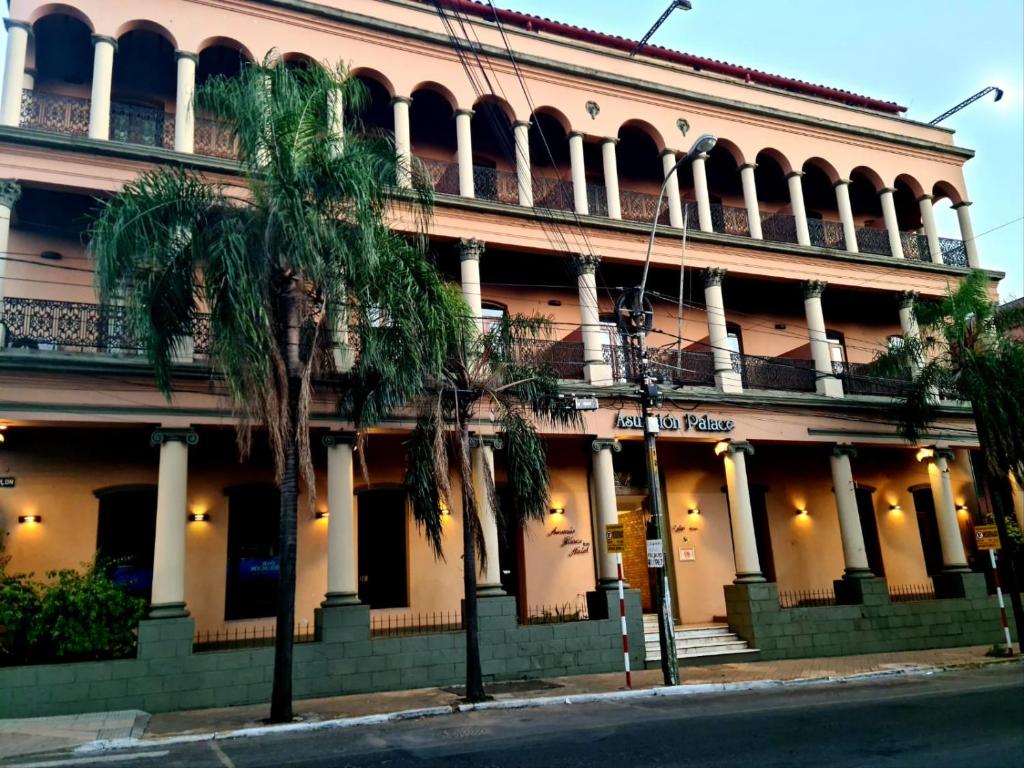 um edifício com palmeiras em frente em Asuncion Palace em Assunção