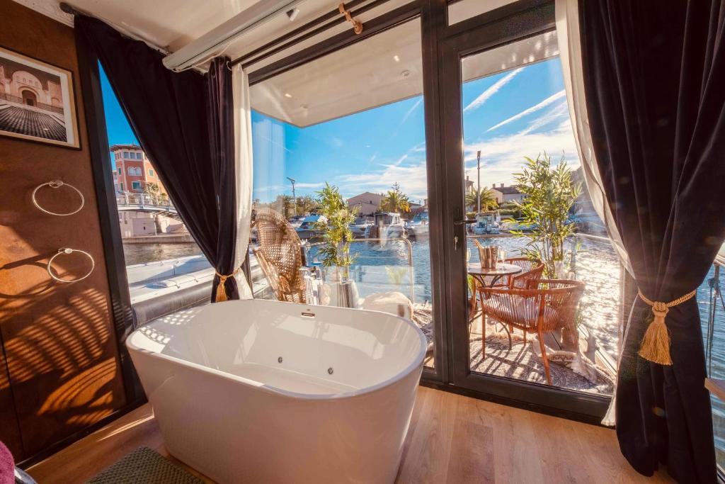 uma banheira num quarto com uma grande janela em Escale Royale Frejus em Fréjus
