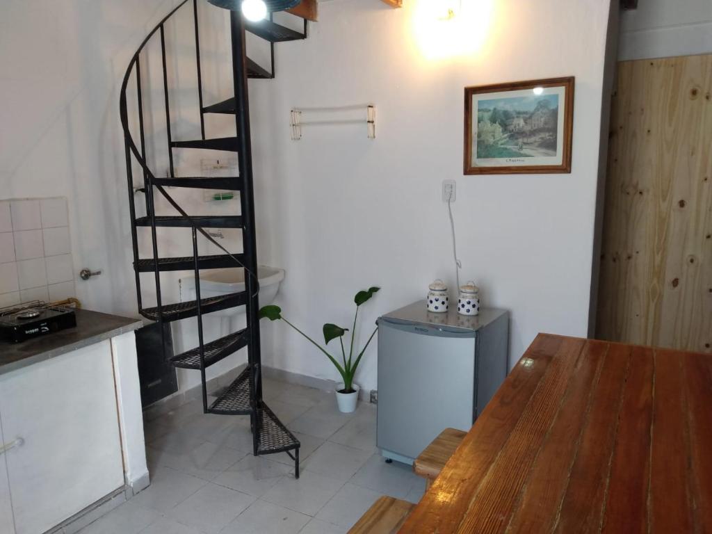 Una escalera de caracol en una cocina con mesa en Duplex en el centro de Concepción del Uruguay en Concepción del Uruguay
