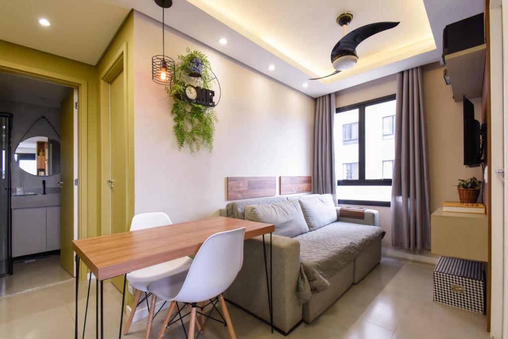 uma sala de estar com um sofá e uma mesa em Apto com churrasq e sala de massagem em Osasco SP em Osasco