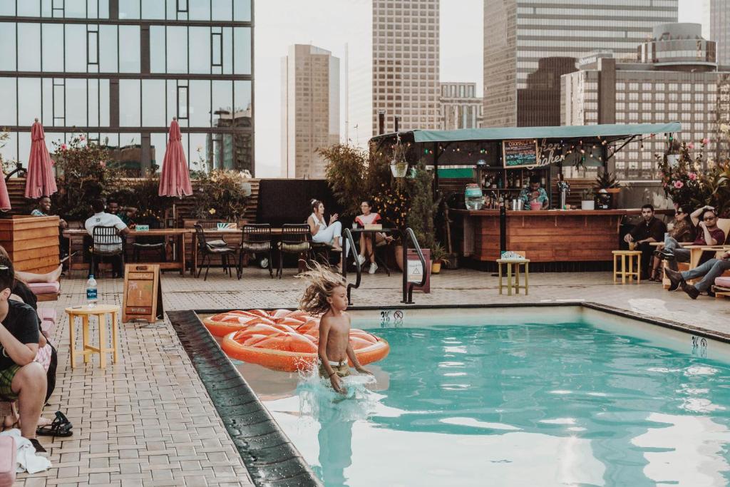 a woman is in a swimming pool in a city at Freehand Los Angeles in Los Angeles