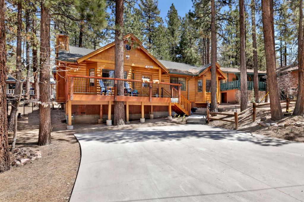 a large log cabin in the woods with a driveway at Retreat to Fox Farm-1662 by Big Bear Vacations in Big Bear Lake