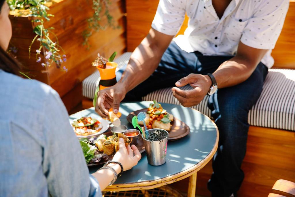 a group of people sitting around a table eating food at Freehand Los Angeles in Los Angeles