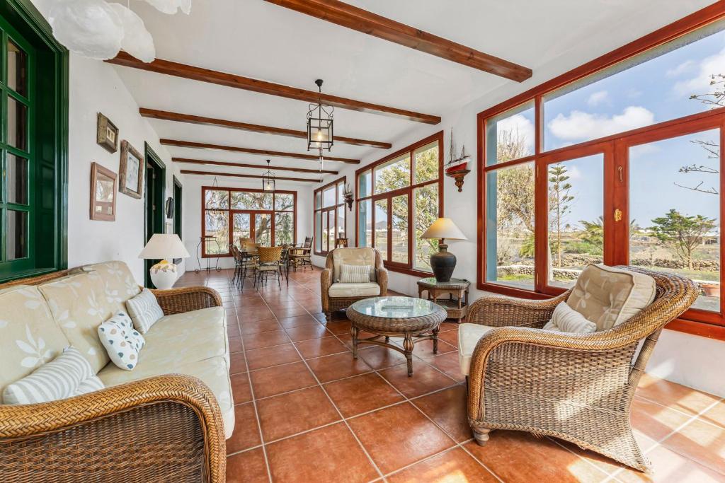 sala de estar con sofá, sillas y ventanas en Finca Los Perales, en La Vegueta