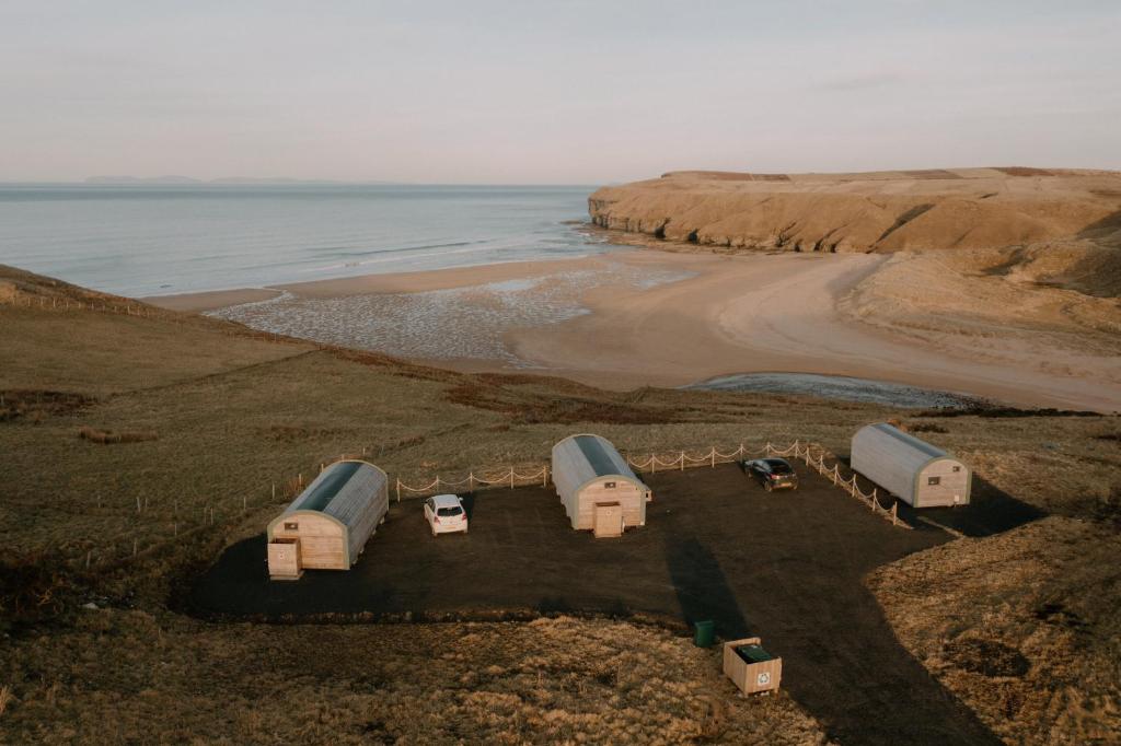 een luchtzicht op een strand met een groep tenten bij Strathy Bay Pods in Strathy