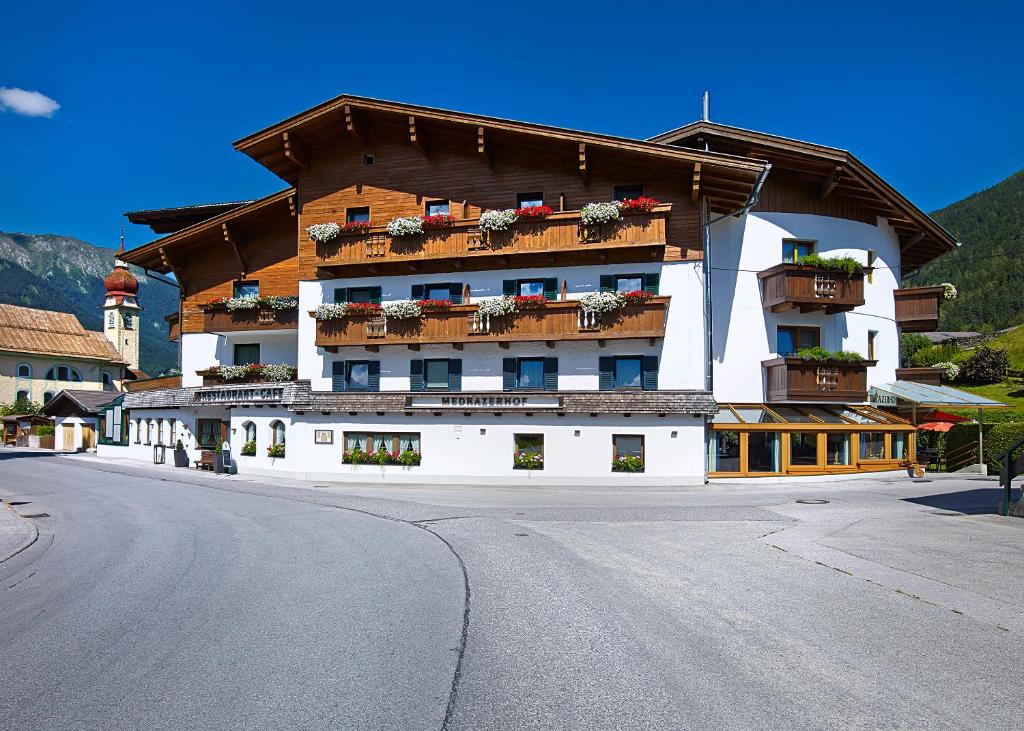 ein großes Gebäude mit Balkonen an der Straßenseite in der Unterkunft Hotel Medrazerhof in Fulpmes