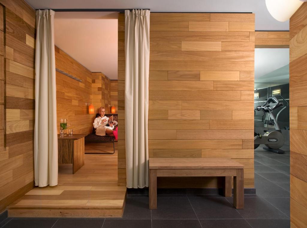 a room with a wooden wall with a bench and a person at Casa Camper Berlin in Berlin