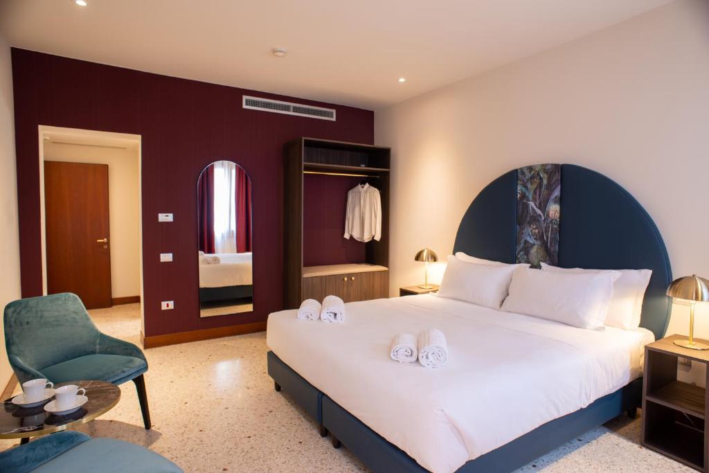 1 dormitorio con 1 cama blanca grande y 1 silla en Palazzina Fortuny en Venecia