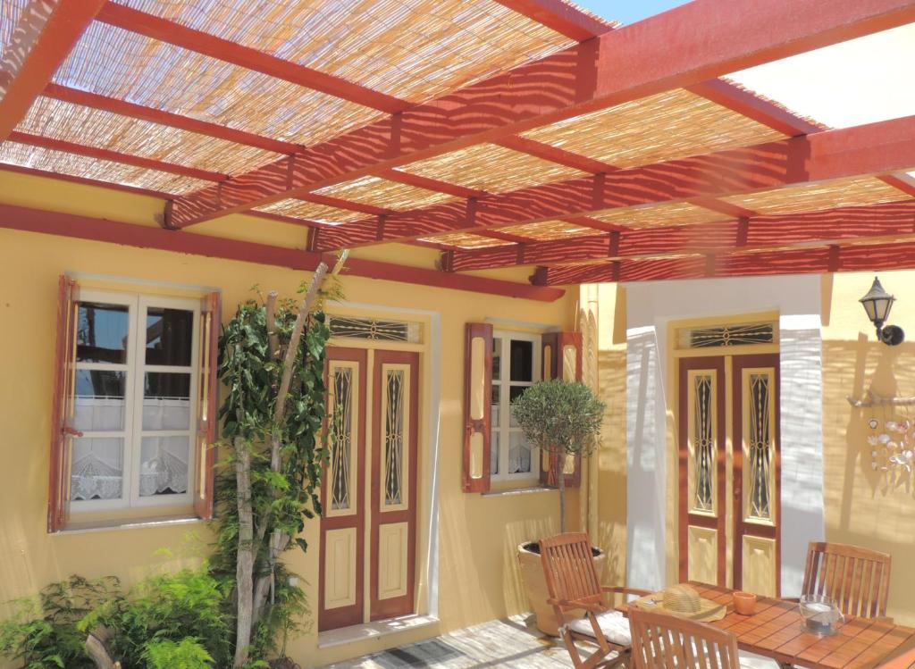 a patio with a wooden pergola on a house at Aloustina's House in Symi