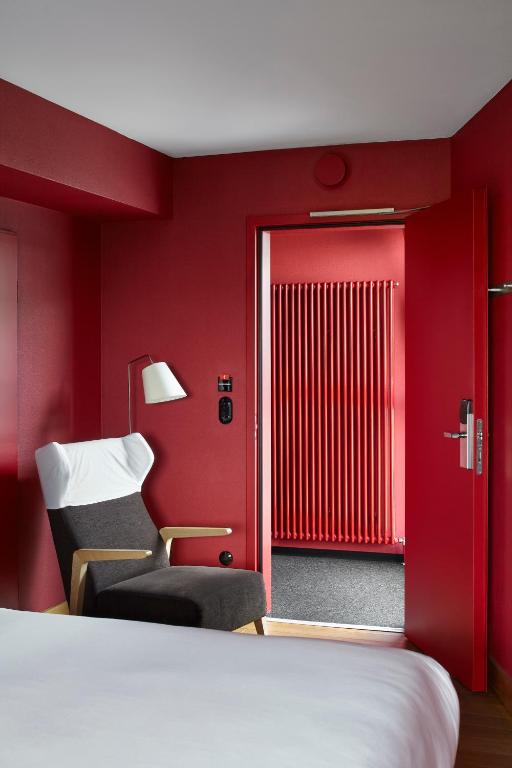 a red room with a bed and a chair at Casa Camper Berlin in Berlin