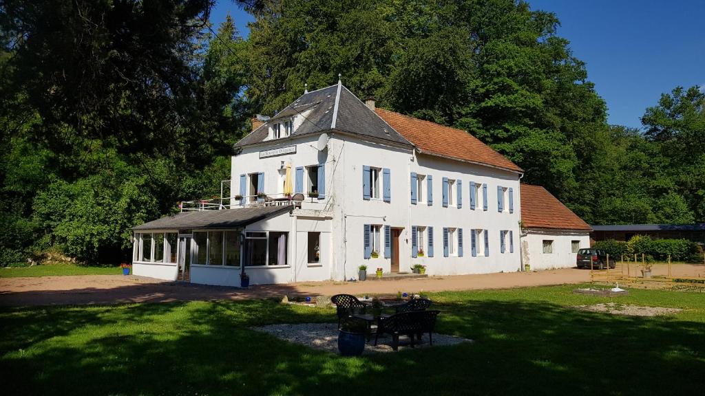 un gran edificio blanco con techo de gambrel en La Nouvelle Diligence en Montsauche