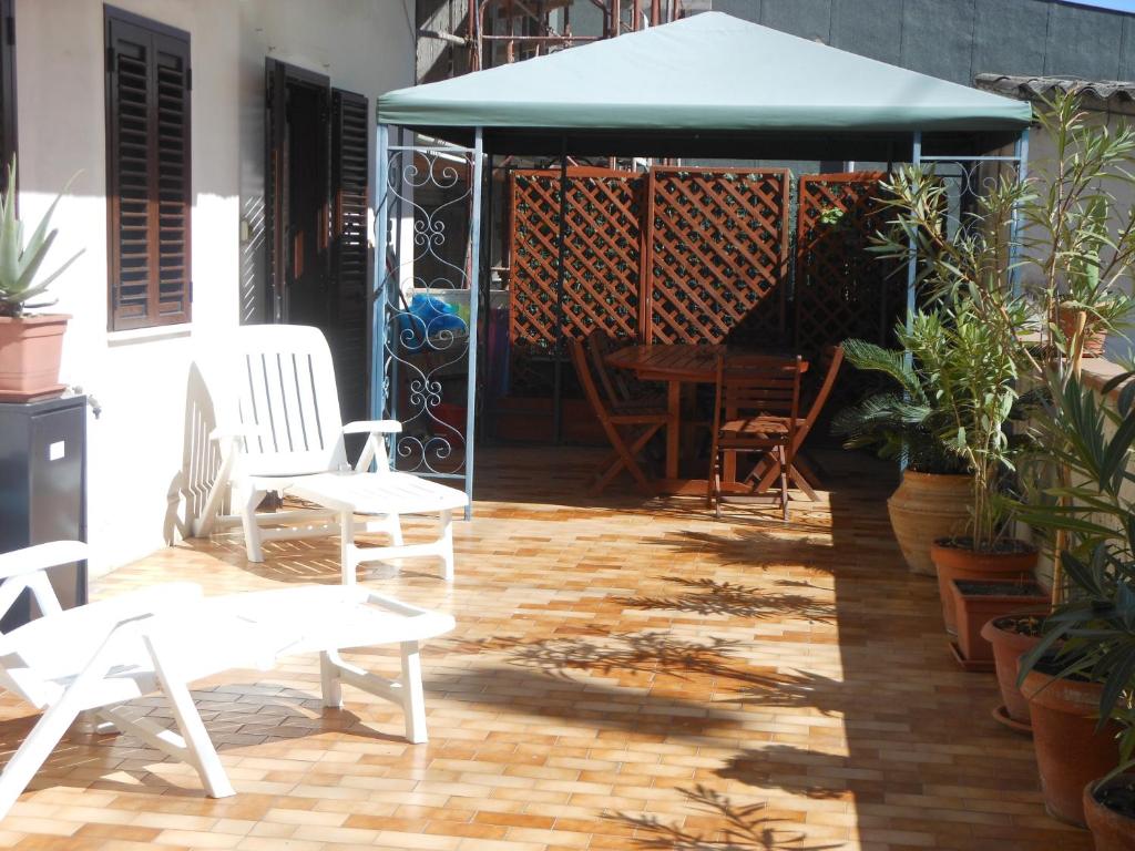 un patio con cenador, mesa y sillas en Casa Vacanze Patrizia, en Acireale