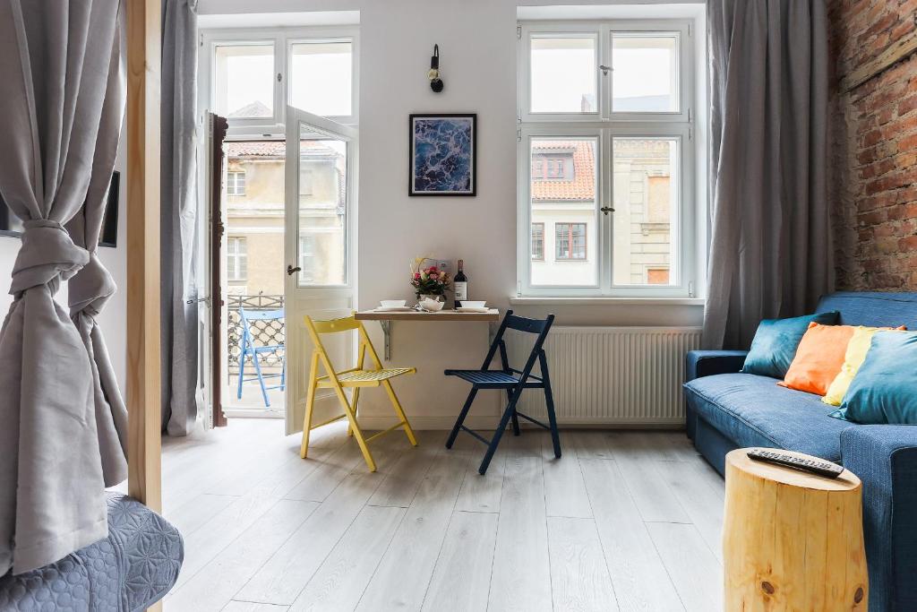 a living room with a blue couch and chairs at Simply Modern Apartments in Toruń