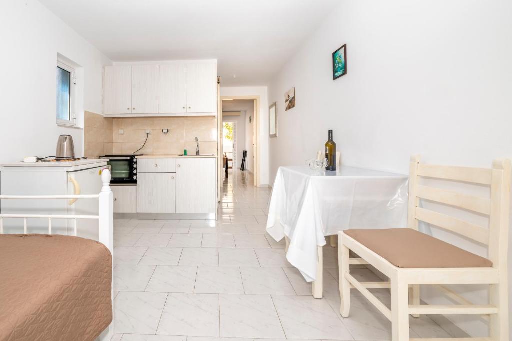 a kitchen with white cabinets and a table in a room at Villa Giorgos in Kefalos