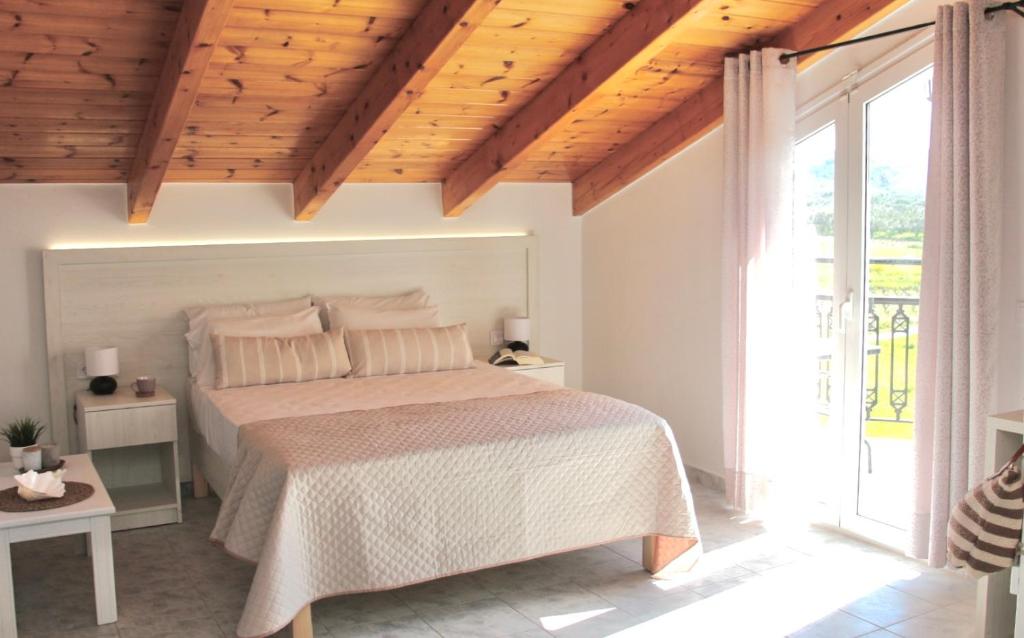 a bedroom with a bed with a wooden ceiling at Comfy Loft at Regina Apartments in Alikanas