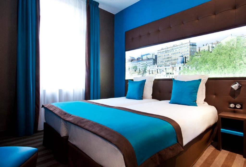 Postel nebo postele na pokoji v ubytování Hotel des Savoies Lyon Perrache