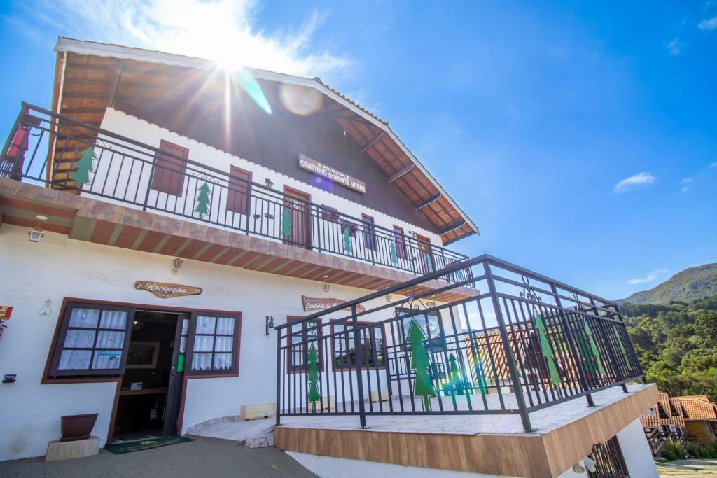 a building with a balcony on the side of it at Pousada Cantinho De Monte Verde in Monte Verde