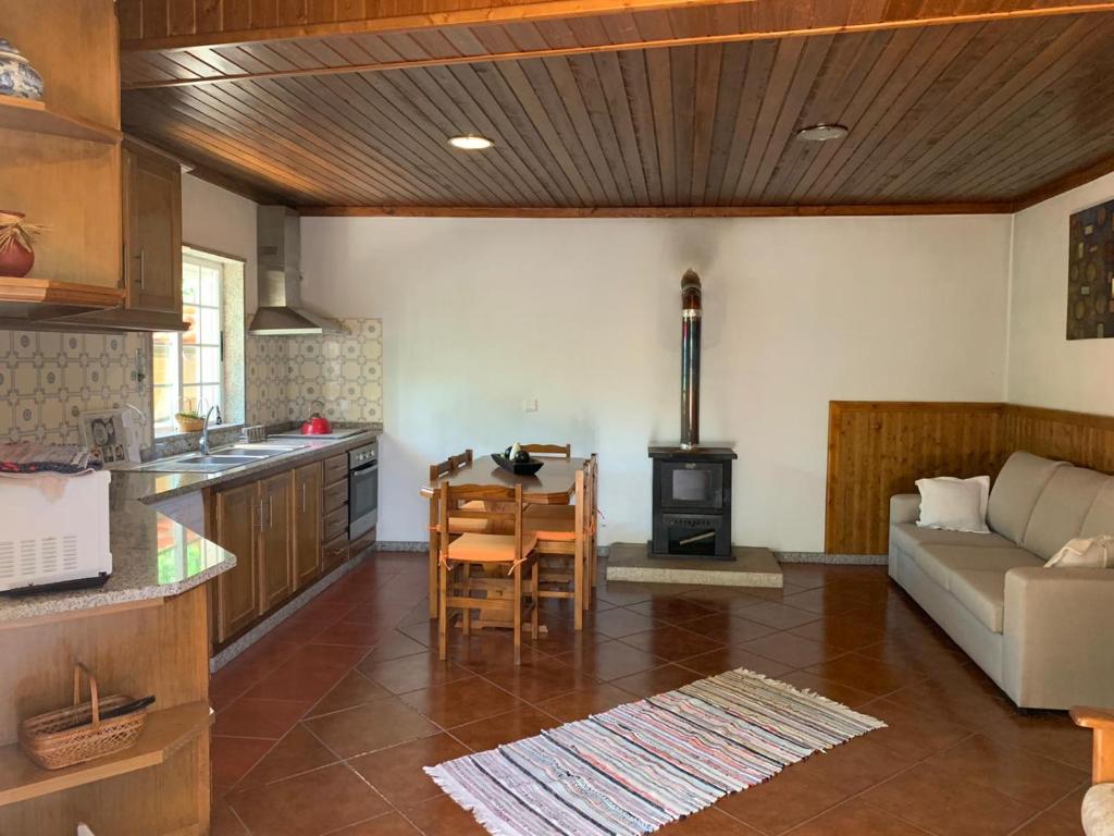 a kitchen and living room with a couch and a stove at Casa do Bairro Alto in Cerva