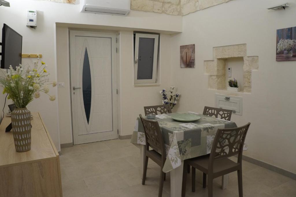 - une salle à manger avec une table, des chaises et une porte dans l'établissement CASETTA SALVATORE, à Ostuni