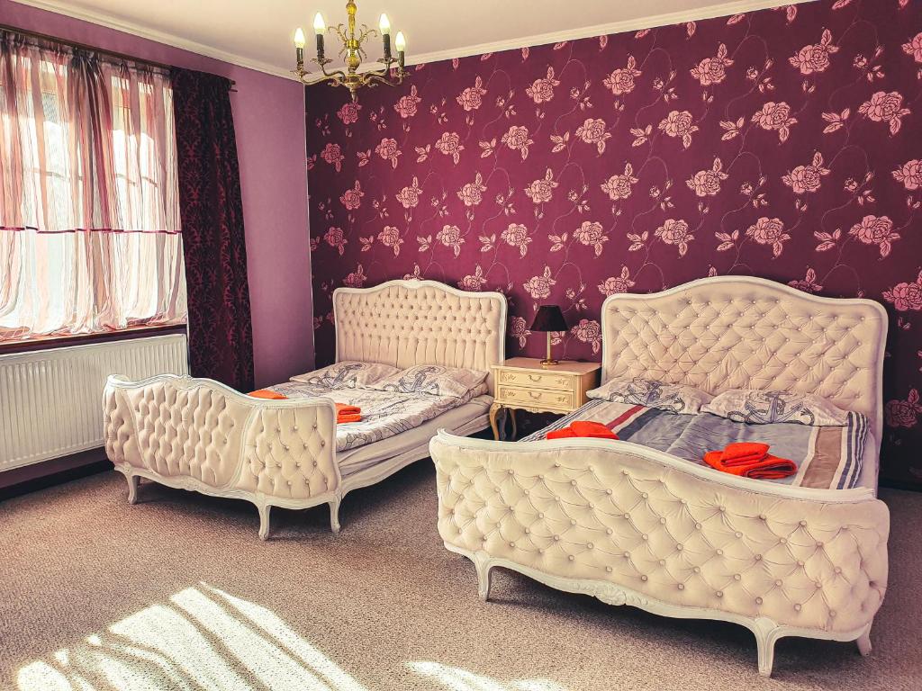 ヴィスワにあるApartamenty nad Wisłą Renesansの紫の壁のベッドルーム1室(ベッド2台付)