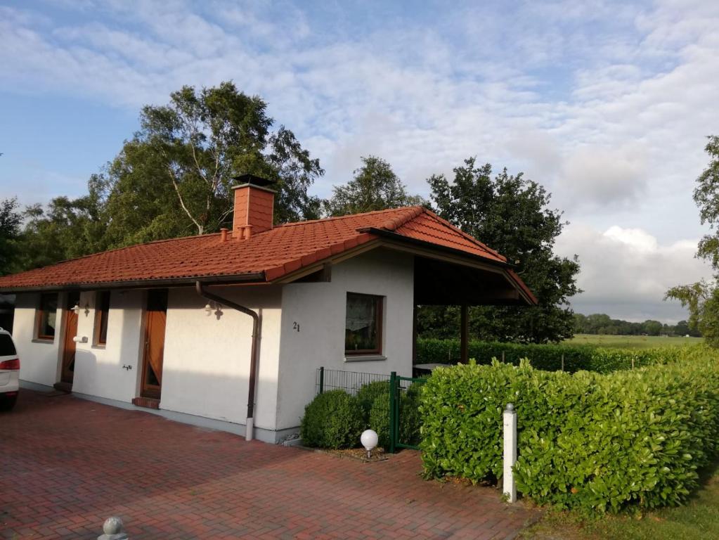 una piccola casa bianca con tetto rosso di Haus Vier Pfoten - Hundefreundliches Ferienhaus an der Nordsee a Schweiburg