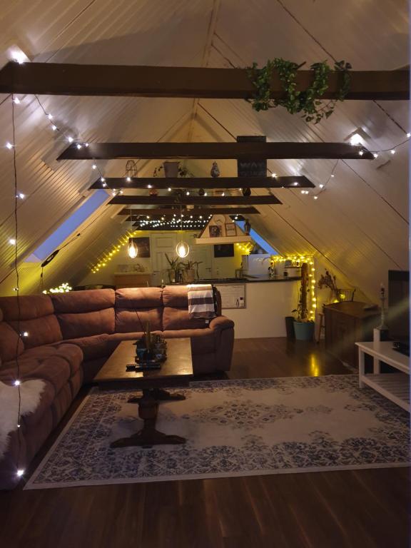 una sala de estar con un sofá de cuero marrón y luces en D'Lyon Stud and Sporthorses, en Asarum