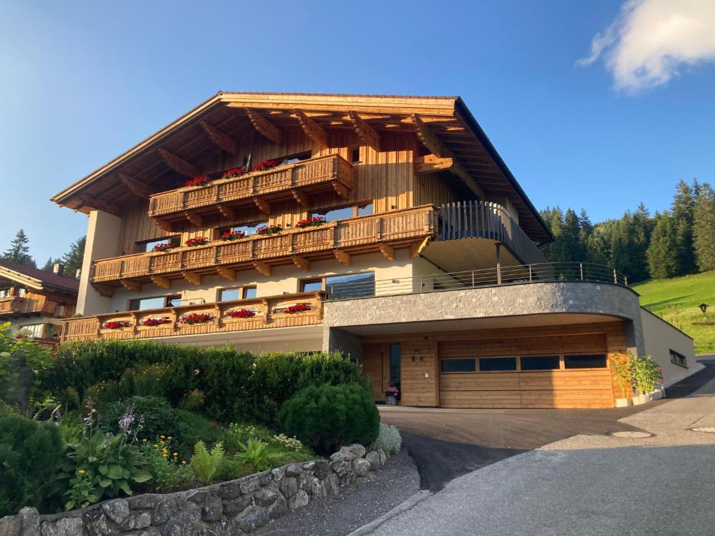 ein großes Haus mit Balkon seitlich in der Unterkunft Auf der Sonnenseite in Schattwald