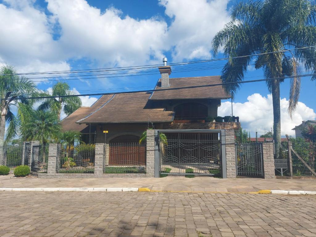 un bâtiment avec un portail et une clôture dans l'établissement Casa de Pedra-Vale dos Vinhedos -RS, à Monte Belo