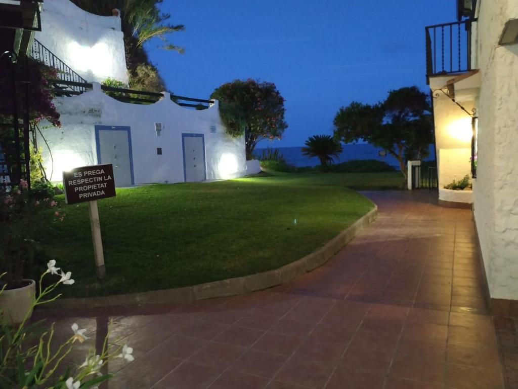a sign in front of a house at night at Little Paradise . Apartment in front of the sea in Comarruga