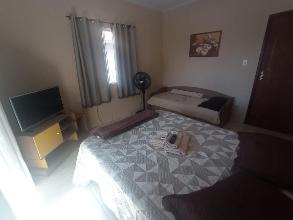 um pequeno quarto com uma cama e uma televisão em APTO do JOCKEY Galdino em Campos dos Goytacazes