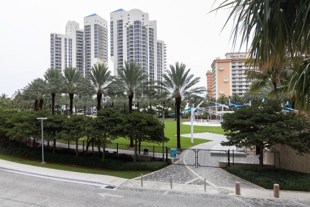 a park with palm trees in front of tall buildings at Ocean Reserve - Park View 1 Bedroom in Miami Beach