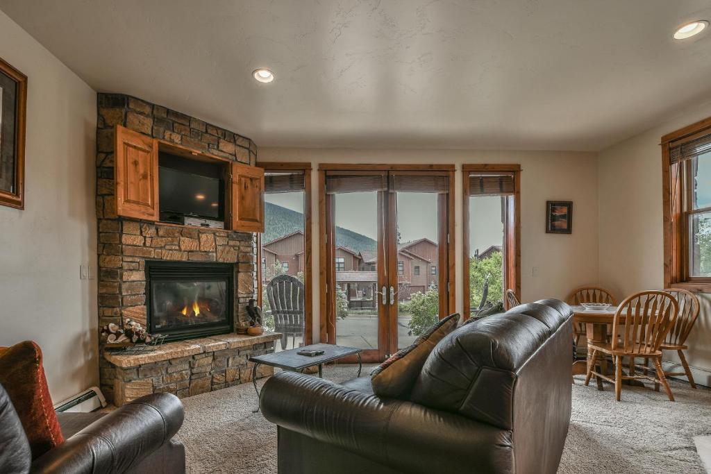 a living room with a leather couch and a fireplace at Antlers Gulch 501 in Keystone