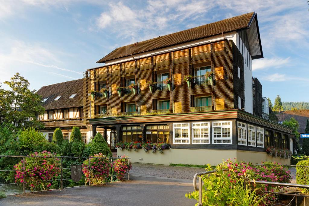 un grande edificio con fiori di fronte di Hotel Hirschen a Glottertal