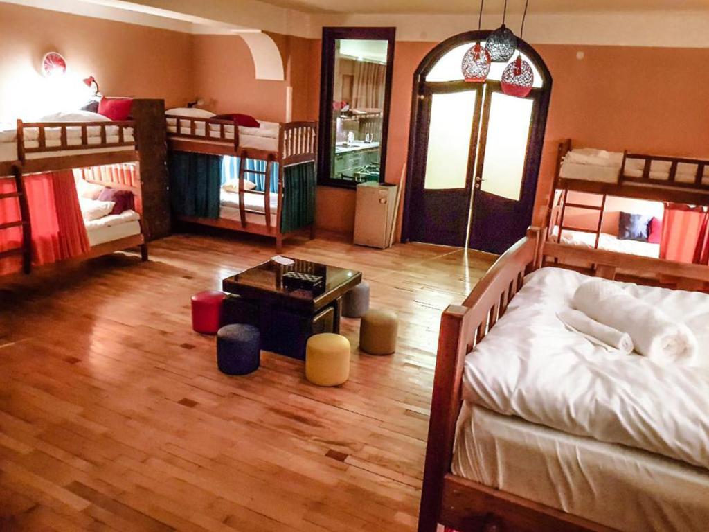 a room with four bunk beds and a table at Museum Hostel in Tbilisi City