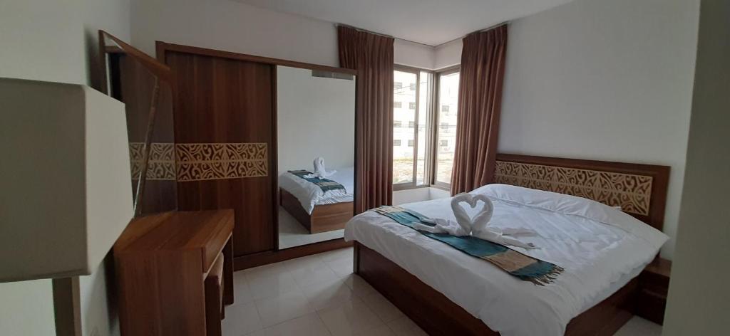 a bedroom with a bed and a large mirror at Furnished Apartments Near McDonald's Al-Madina Al-Monawara St in Amman