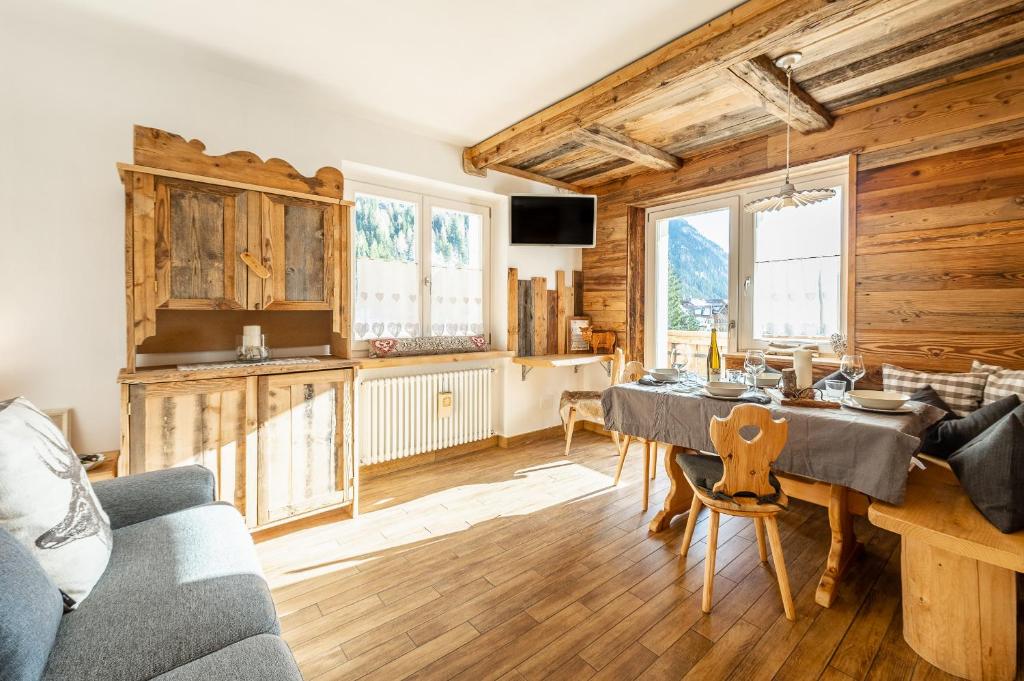 jadalnia ze stołem w pokoju z drewnianymi ścianami w obiekcie Laurino Apartment w mieście Campitello di Fassa