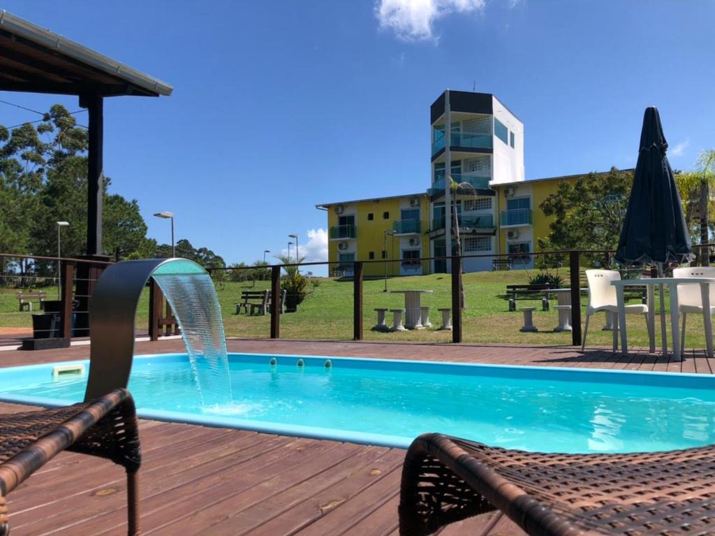 a swimming pool with a water fountain at Hotel Pousada Laguna Rosa in Barra de Ibiraquera