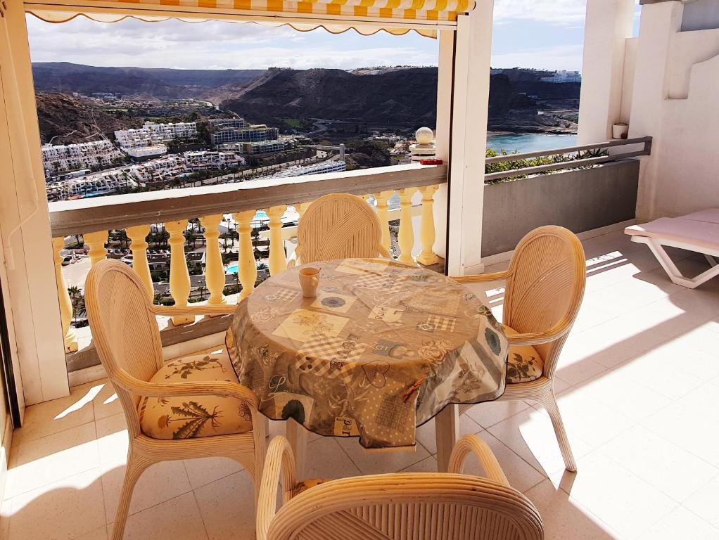 a table and chairs on a balcony with a view at Apartamentos Monseñor in Playa del Cura