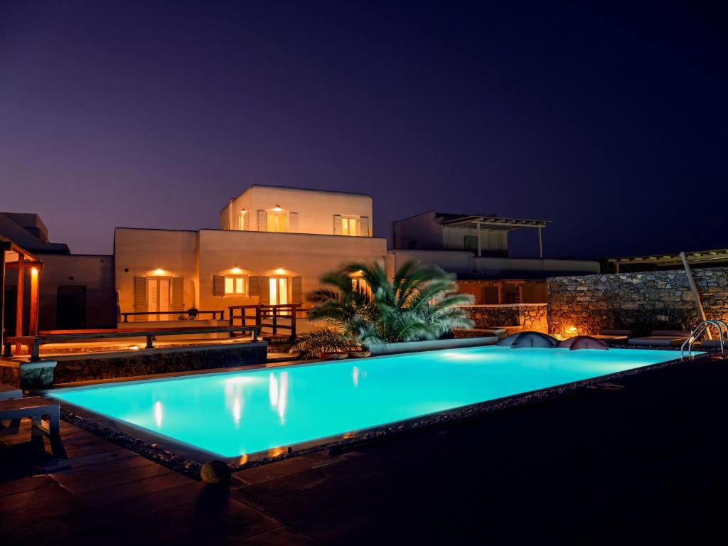 a swimming pool in front of a house at night at Secret Island in Tourlos