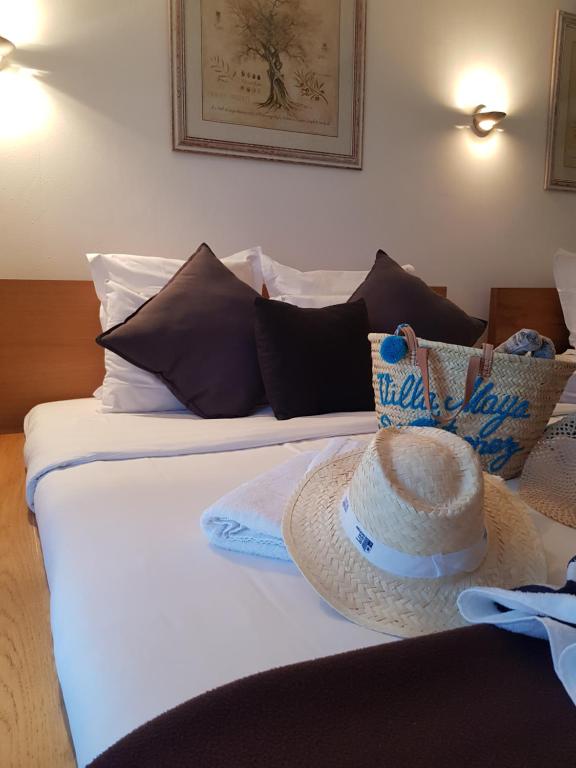 a bed with a straw hat on top of it at Hotel Villa Maya in Saint-Tropez