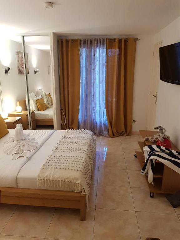 a bedroom with a large bed and a mirror at Hotel Villa Maya in Saint-Tropez