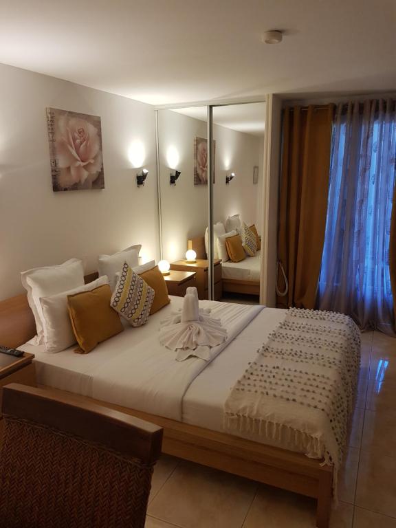 a bedroom with a large bed with a mirror at Hotel Villa Maya in Saint-Tropez