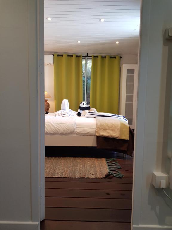 a bedroom with a bed with green curtains at Hotel Villa Maya in Saint-Tropez