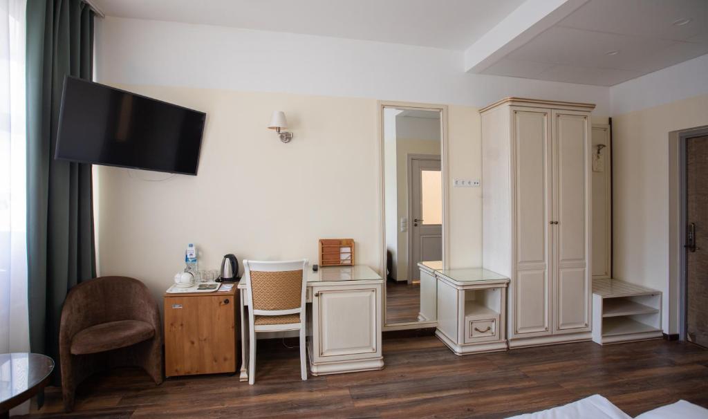 a hotel room with a desk and a tv at Hotel St. Barbara in Tallinn