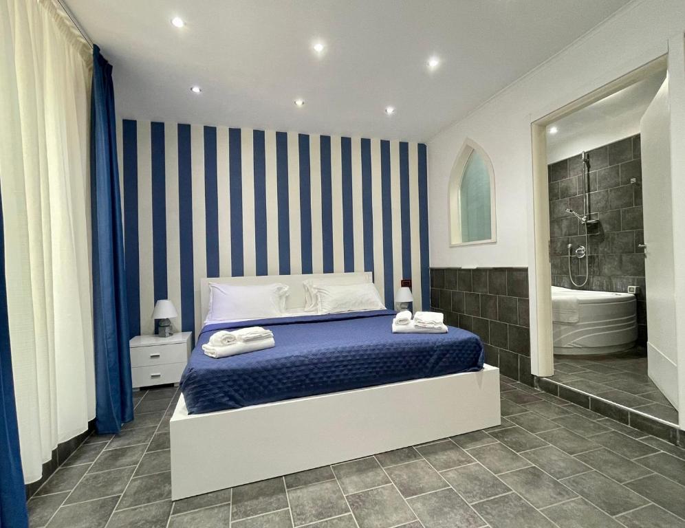 ein Schlafzimmer mit einer blau-weißen gestreiften Wand in der Unterkunft Yacht Club Angioino in Neapel