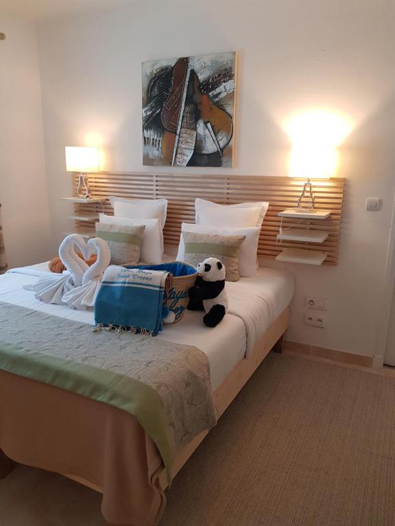 a bedroom with a bed with a stuffed animal on it at Hotel Villa Maya in Saint-Tropez
