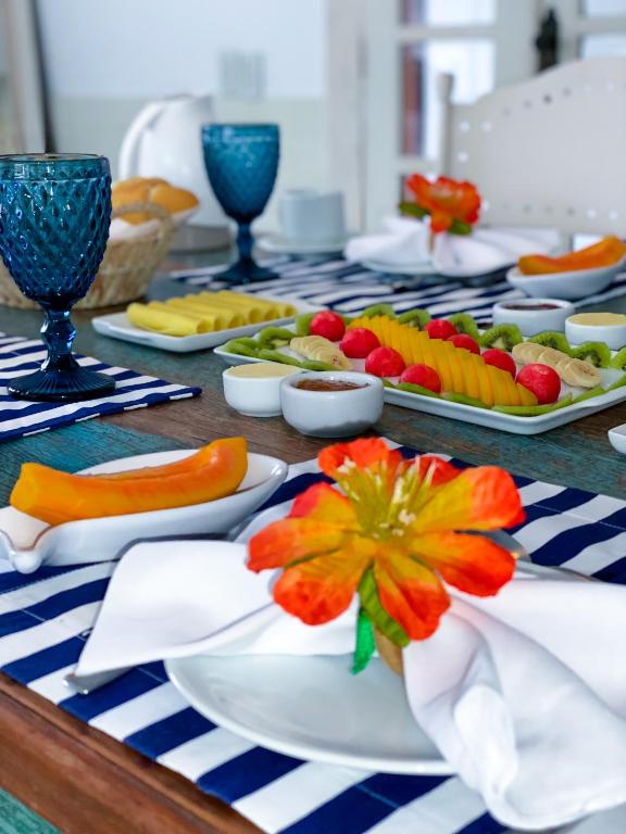 a table with plates of fruit and vegetables on it at La Maison de Vacances in Búzios